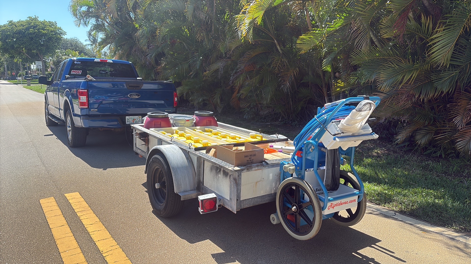 Collegiate Pools service truck and trailer loaded with chemicals on a Palm Beach County route